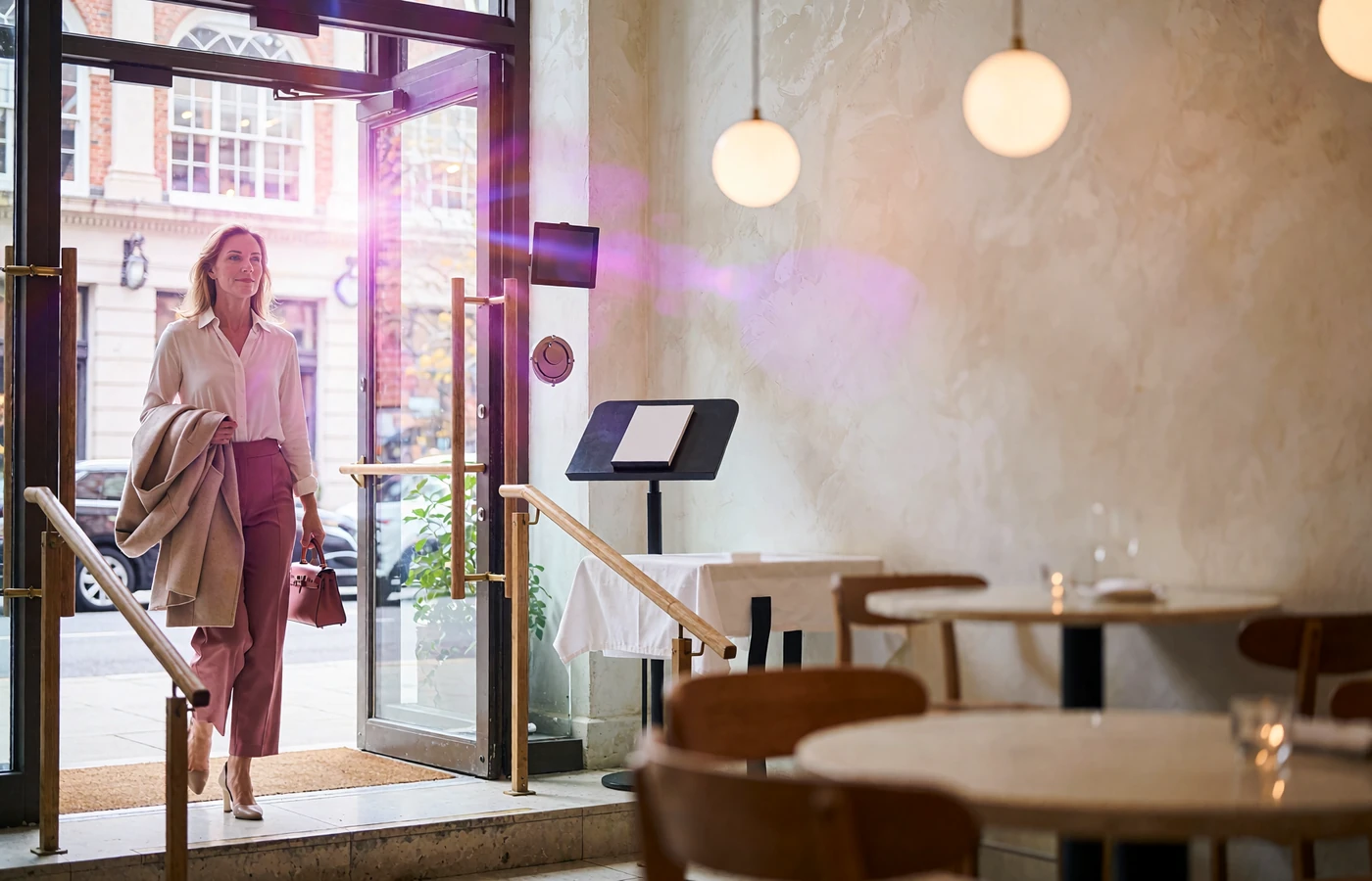 Elegant woman stepping into a bright upscale restaurant entrance for a safe, public first sugar dating meeting